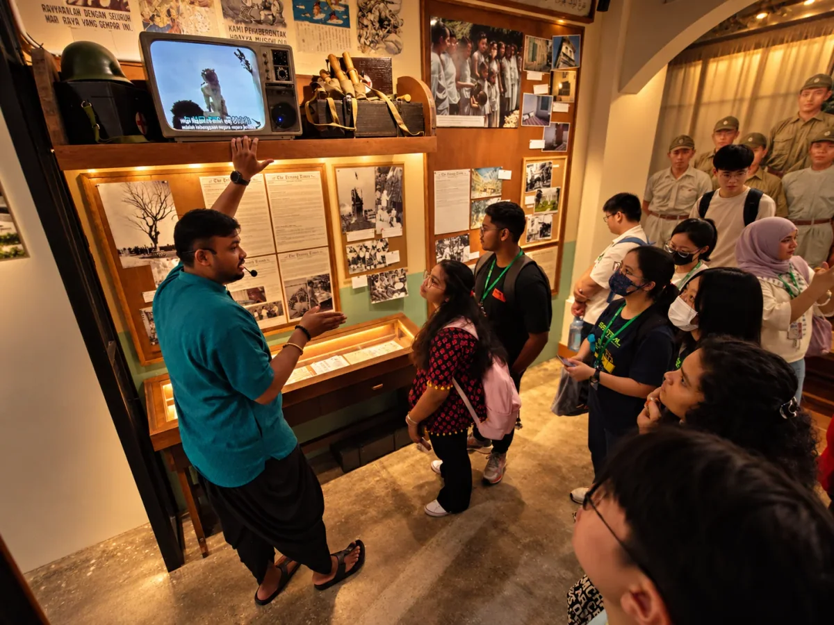 Visitors listening to a guide beside historical exhibits