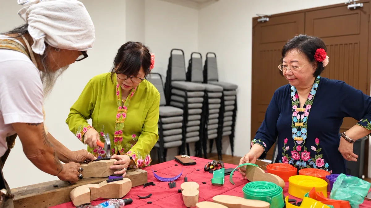 A facilitator guides visitors through a traditional craft workshop